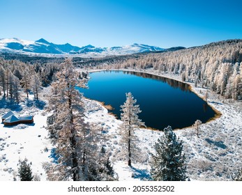 Kidelu lake in Altai mountains, Siberia, Russia. Snow-covered trees and mountains. Aerial drone view. Beautiful winter landscape.