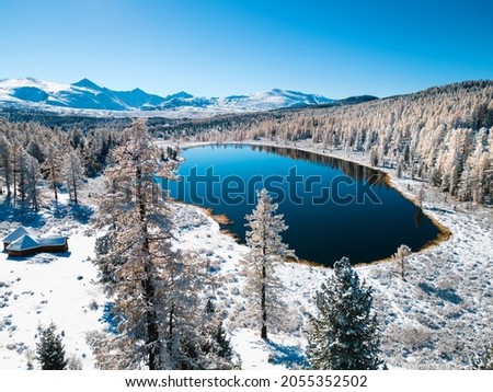 Kidelu lake in Altai mountains, Siberia, Russia. Snow-covered trees and mountains. Aerial drone view. Beautiful winter landscape.