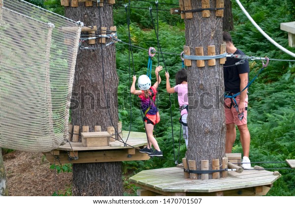kids\
in an adventure park or wood park or  forest park\
