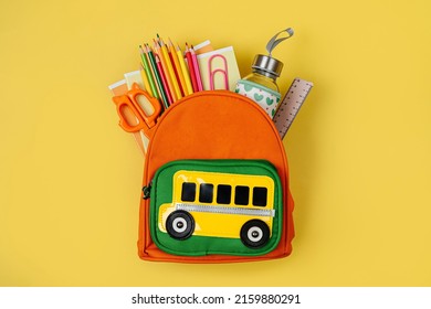 Kids Backpack with school bus on yellow background. Opened School backpack with stationery. Primary School or kindergarten.  - Shutterstock ID 2159880291
