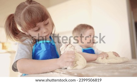 kids are baking. children knead dough and flour in the kitchen. happy family kid concept. baby children bake pizza dough. brother sister baking cookies. teamwork children knead dough dream and flour