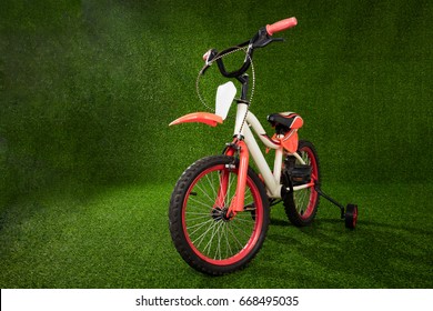 Kids Bicycle Parked On The Green Grass At Outdoor Park