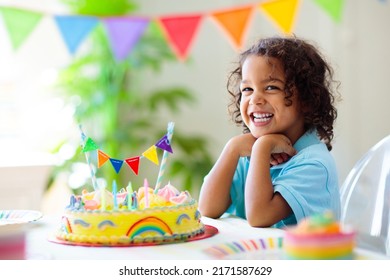 Kids birthday party. Children celebrate with colorful cake and gifts. Little curly boy blowing candles and opening birthday presents. Friends play with rainbow confetti. Party home decoration. - Powered by Shutterstock