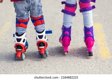 Kids boy and girl having fun outdoor while riding roller skates. Children on rollerblades. Roller skating in the park near seashore.