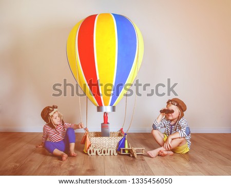 Kids boy and girl playing with colorful hot air balloon. Children playing in aviator. Travel and adventure concept. Child, summer, vacation