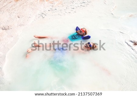 Kids boy and girl relaxing in hot white spring water jet. Thermal bathes in Turkey. Hatural hot spring spa baths outdoors. Child in sunglasses in summer vacation.