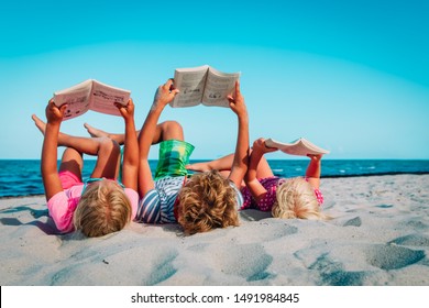 kids -boy and girls- reading books at beach vacation