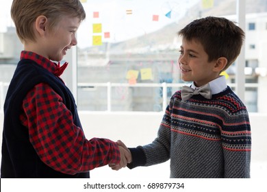 Kids as business executives shaking hands in office - Powered by Shutterstock