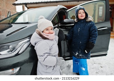 Kids Charging Electric Car In The Yard Of House At Winter.