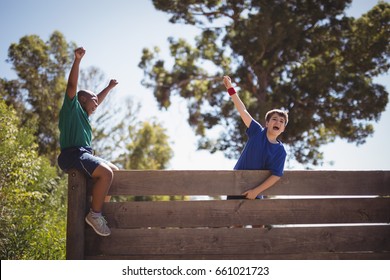 Kids Cheering On Wooden Wall During Obstacle Course In Boot Camp