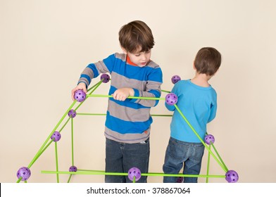 Kids, children building a fort and sharing construction pieces