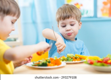 Kids Children Eating Vegetables In Kindergarten Or At Home