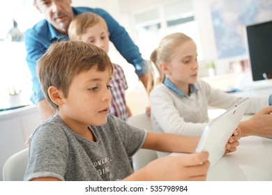 Kids In Classroom Learning With Digital Tablet