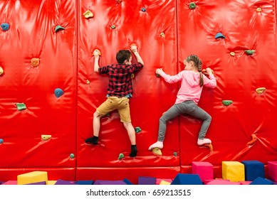 Kids Climbing On A Wall In Attraction Playground