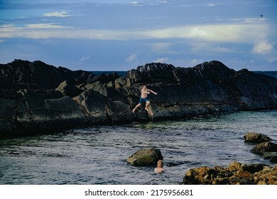 Kids Climbing Rock Wall At The Tanks Tourist Attraction Natural Rock Pool At Forster, NSW Australia