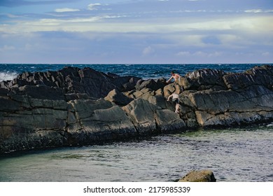 Kids Climbing Rock Wall At The Tanks Tourist Attraction Natural Rock Pool At Forster, NSW Australia