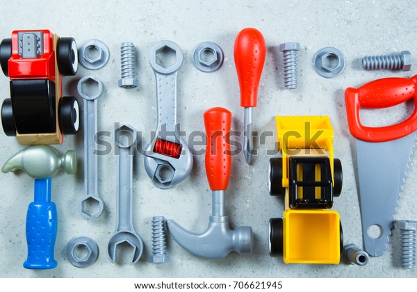 Kids construction toys tools , Colorful kids toys\
border. Plastic toy tools,car. bolts and nuts on white background\
as frame. Top view