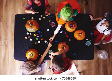 Kids In Costume Decorating A Pumpkin  