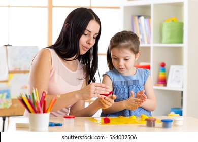 Kids creativity. Child girl with her mother sculpting from play clay
