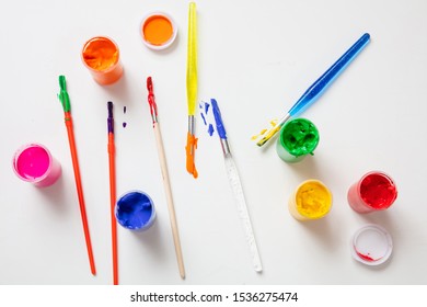 Kids Creativity. Colorful Finger Paints Set And Paint Brushes On White Color Background, Top View