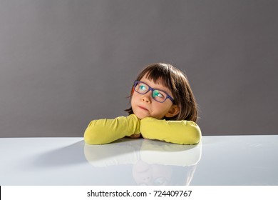 Kid's Critical Thinking With Serious Little Child Leaning Her Head On A School Table, Looking Away With Imagination, Reflection, Doubt And Gifted Thoughts About Future, Copy Space