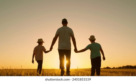 Kids dad travels to sunset, happy family. Silhouette. Father, sons walk together holding hands, park, sunset. Dad plays with his child outside. Childhood dream, father. Childhood adolescence weekend - Powered by Shutterstock