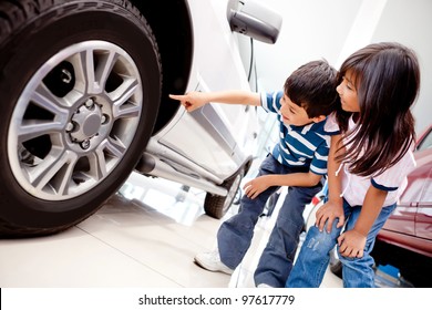 Kids In The Dealer Looking At Car Wheels