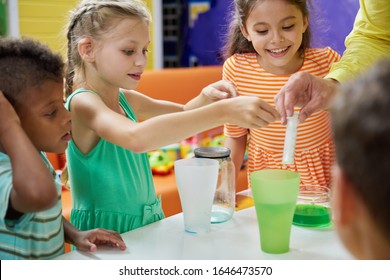 Kids Doing Chemical Experiment At Entertainment Center. Flasks With Colorful Liquid On Table. Childrens Party Entertainment.