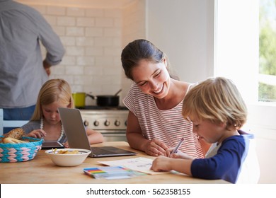 Kids doing homework at kitchen table with mum, close up - Powered by Shutterstock