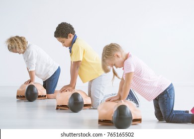 Kids doing resuscitation training on medical dummy during first aid course - Powered by Shutterstock