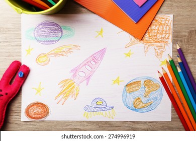 Kids Drawing On White Sheet Of Paper On Wooden Table, Top View