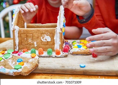 kids eat gingerbread house on Christmas. Children's hands and a broken gingerbread house. closeup