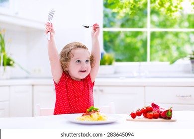 Kids Eat Pasta. Healthy Lunch For Children. Toddler Kid Eating Spaghetti Bolognese In A White Kitchen At Home. Preschooler Child Cooking Noodles With Tomato And Pepper For Dinner. Food For Family.