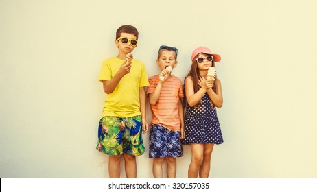 Kids Eating Gelato And Soft Serve Ice Cream. Boys And Little Girl In Sunglasses Enjoying Summer Holidays Vacation. Instagram Filter.