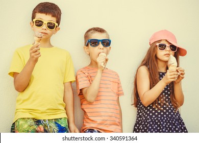 Kids Eating Gelato And Soft Serve Ice Cream. Boys And Little Girl In Sunglasses Enjoying Summer Holidays Vacation. Instagram Filter.