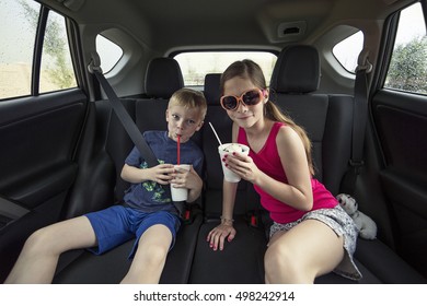 Kids Eating A Treat In The Back Of Their Car After Going To A Drive Thru Restaurant