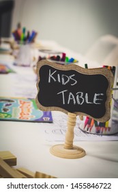 Kids Entertainment Table At A Wedding With Colorful Markers In A Jar And Paper With A Chalkboard Sign