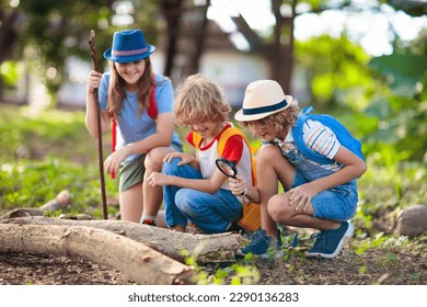 Kids explore nature. Children hike in sunny summer park. Scout club and science outdoor class. Boy and girl watch plants through magnifying glass. Kid exploring environment. Young explorer adventure. - Powered by Shutterstock