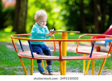 Kids explore nature. Children play in sunny park. Child on playground in beautiful summer park. Outdoor fun for active family. Kid on swing and slide. - Powered by Shutterstock