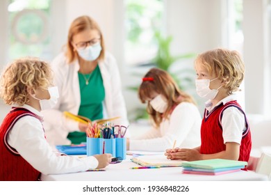 Kids In Face Mask In School Class. Child Back To School After Coronavirus Lockdown. Primary Child In Covid-19 Pandemic. Safety And Virus Spread Prevention. Student In Surgical Mask. Social Distancing.