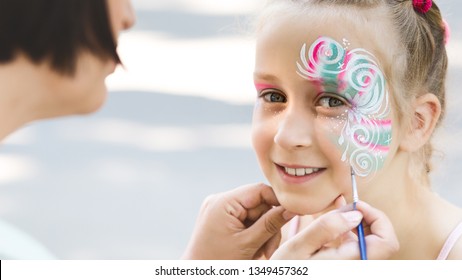 Kids Face Painting. Adorable Little Girl Getting Creative Pattern On Her Face, Free Space