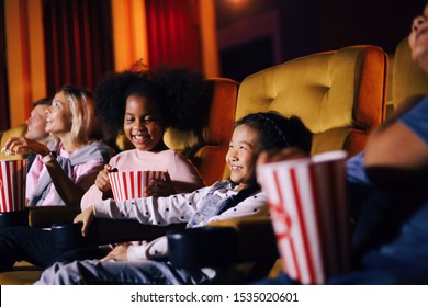 Kids And Family Watching Movie In Cinema On Weekend.