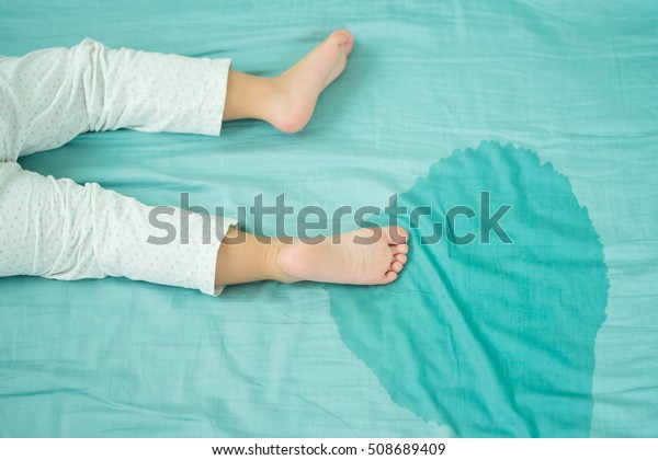 孩子的脚和尿在床垫 小女孩的脚和尿尿在床单上在早晨 儿童发展的概念 库存照片 立即编辑