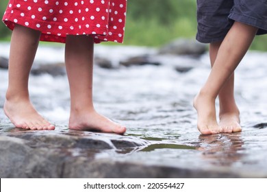 Kid's Feet Wading In Shallow Water