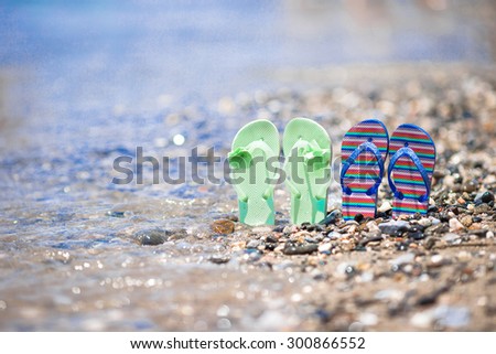 Kids flip flops on beach in front of the sea