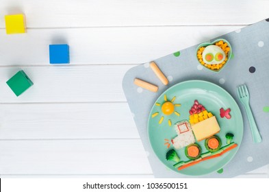 Kids Food Art Concept: Car From Rice, Sandwich And Fresh Fruits And Vegetables On White Wooden Background With Toys With Blank Space For Text; Top View, Flat Lay