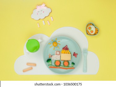 Kids Food Art Concept: Car From Rice, Sandwich And Fresh Fruits And Vegetables On The Plate With Cloud Napkin And Cloud Biscuit On The Yellow Background; Top View, Flat Lay