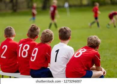 Kids Football Team. Children Football Academy. Substitute Soccer Players Sitting on Bench. Young Boys Playing European Football Game. Soccer Tournament Match for Children - Powered by Shutterstock