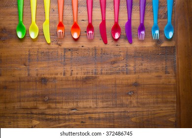 Kids funny eating. Composition of Colorful cutlery on wooden table