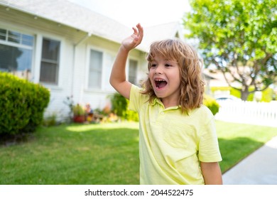 Kids with funny face bye bye hand on backyard. Emotional amazed excited child. Little boy with good bye or hello sign.